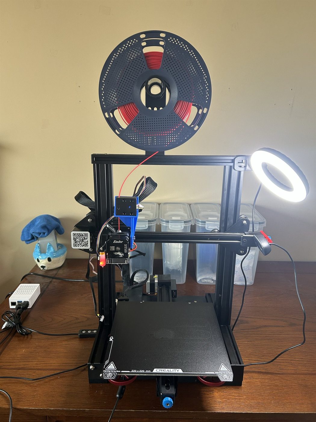 The rebuilt Ender 3 V2 with a direct-drive extruder, spring steel bed, ring light, and the Raspberry Pi 5 control server beside it