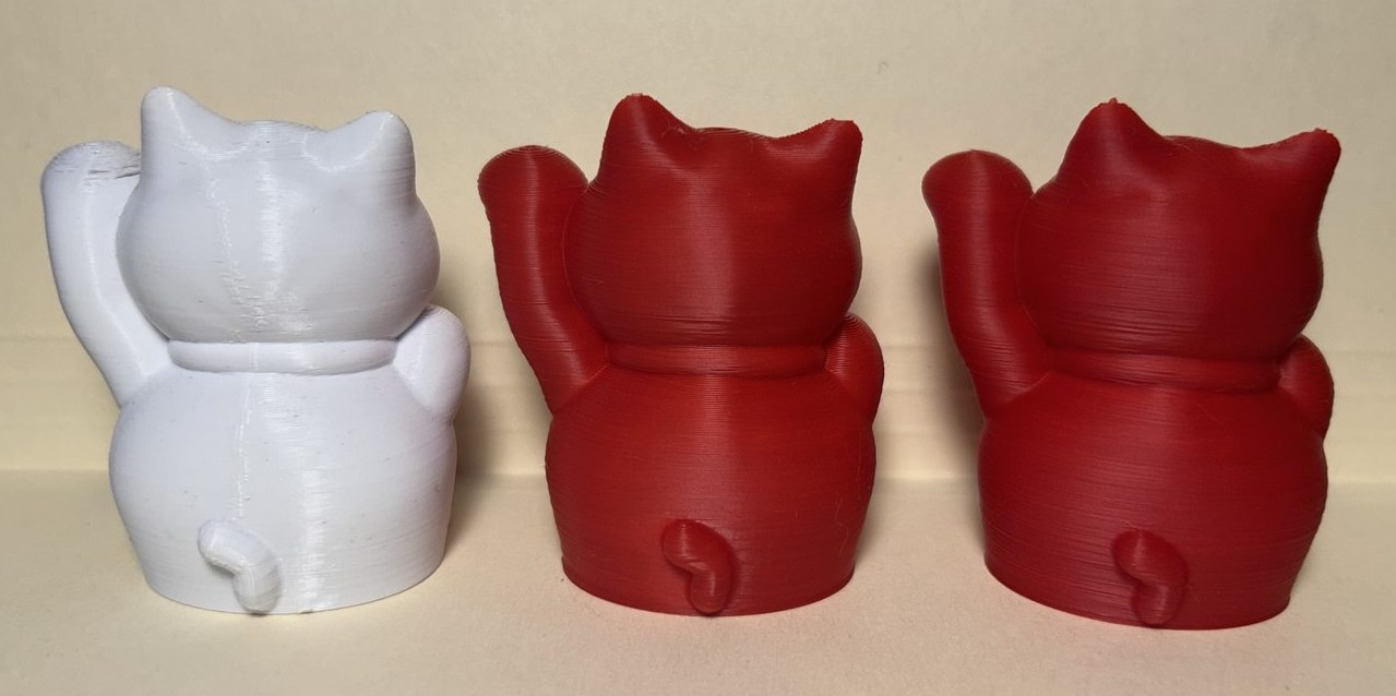 The three lucky cat prints viewed from the back, showing the vertical seam on the original
